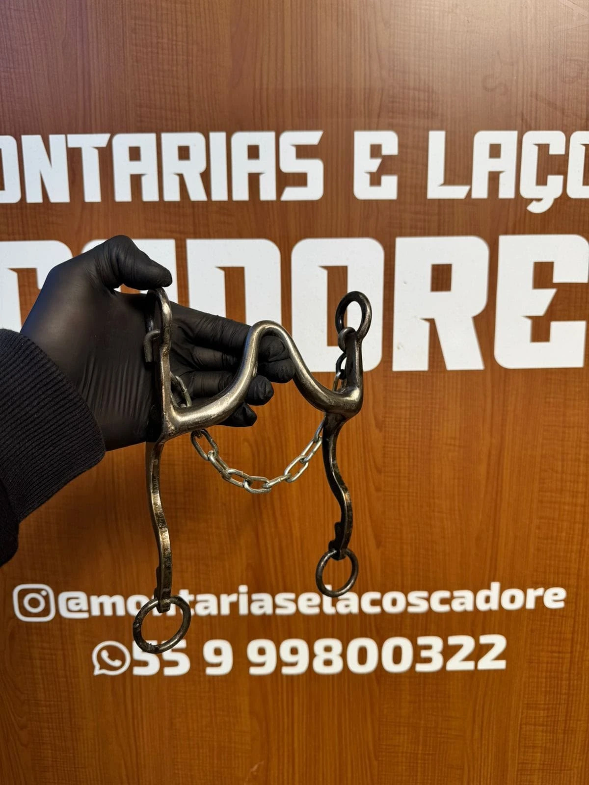 Freio duro com barbela de corrente visto de lado, seguro com luva preta
