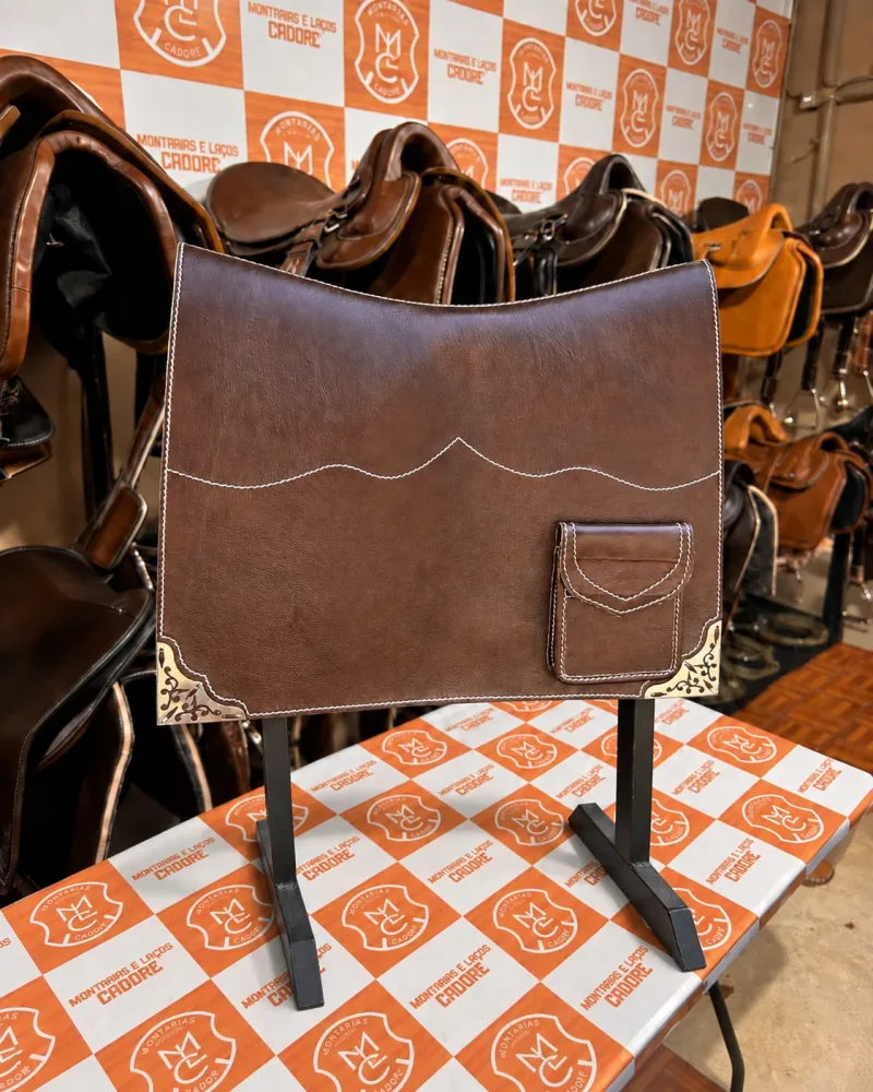 Badana de couro café com costura ondulada, bolso de lapela e cantoneiras de metal trabalhadas