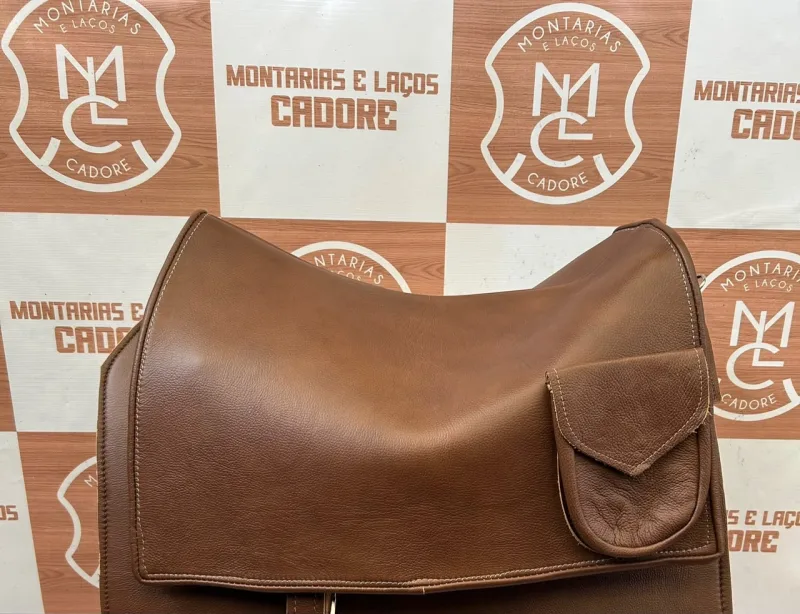 Badana quadrada de couro marrom liso com bolso de lapela, sobre cavalete na loja