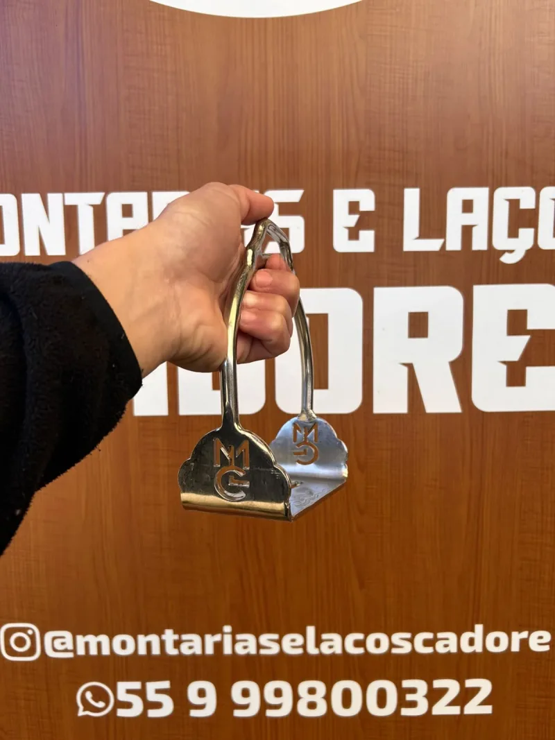 Estribo de inox de base larga, com arco estreito e a logo da loja nas chapas