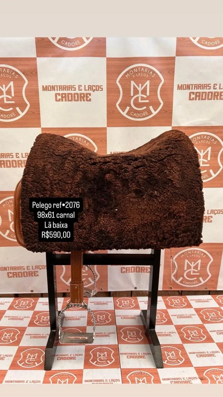 Pelego de lã sobre uma sela no cavalete, com a referência 2076, a medida e o preço escritos na foto