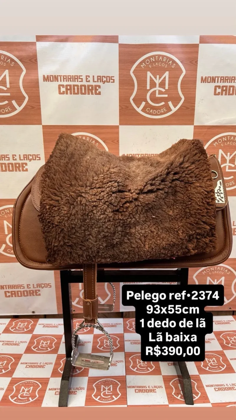 Pelego de lã marrom sobre uma sela no cavalete, com a referência 2374, a medida e o preço escritos na foto