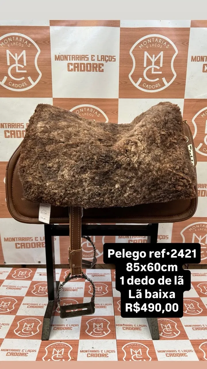 Pelego de lã sobre uma sela no cavalete, com a referência 2421, a medida e o preço escritos na foto