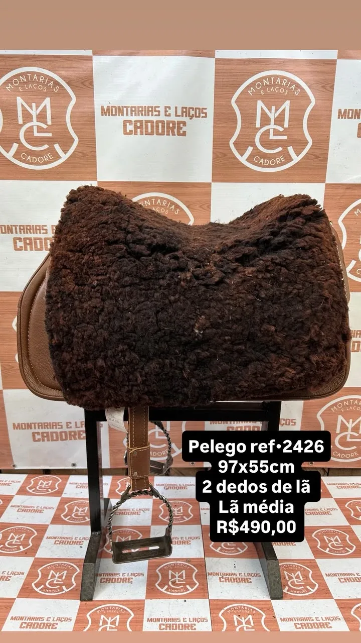 Pelego de lã sobre uma sela no cavalete, com a referência 2426, a medida e o preço escritos na foto