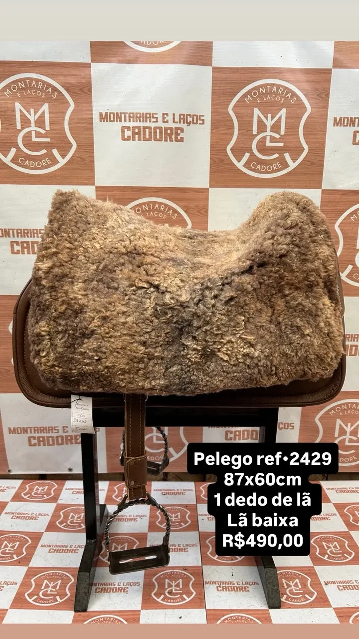 Pelego de lã sobre uma sela no cavalete, com a referência 2429, a medida e o preço escritos na foto