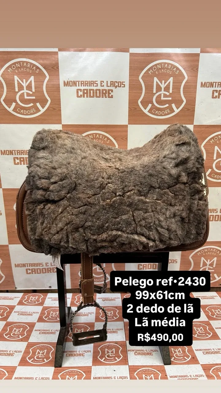 Pelego de lã sobre uma sela no cavalete, com a referência 2430, a medida e o preço escritos na foto