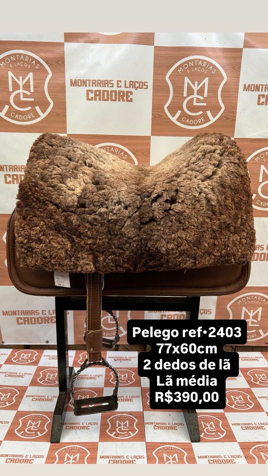 Pelego de lã sobre uma sela no cavalete, com a referência 2403, a medida e o preço escritos na foto