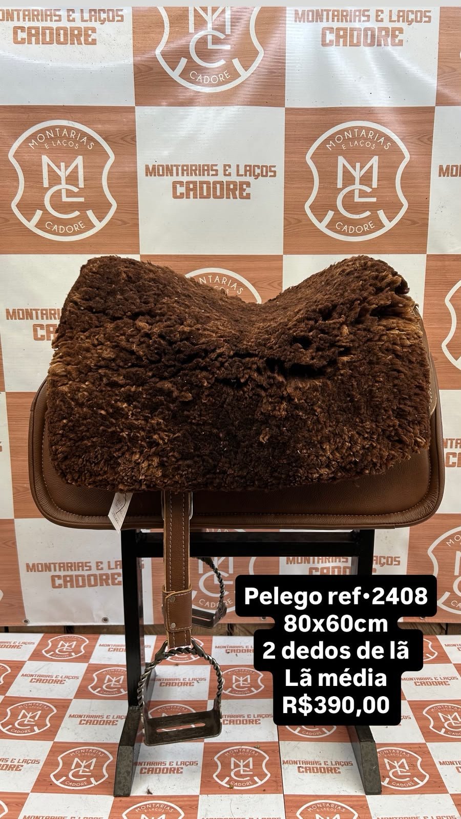 Pelego de lã sobre uma sela no cavalete, com a referência 2408, a medida e o preço escritos na foto