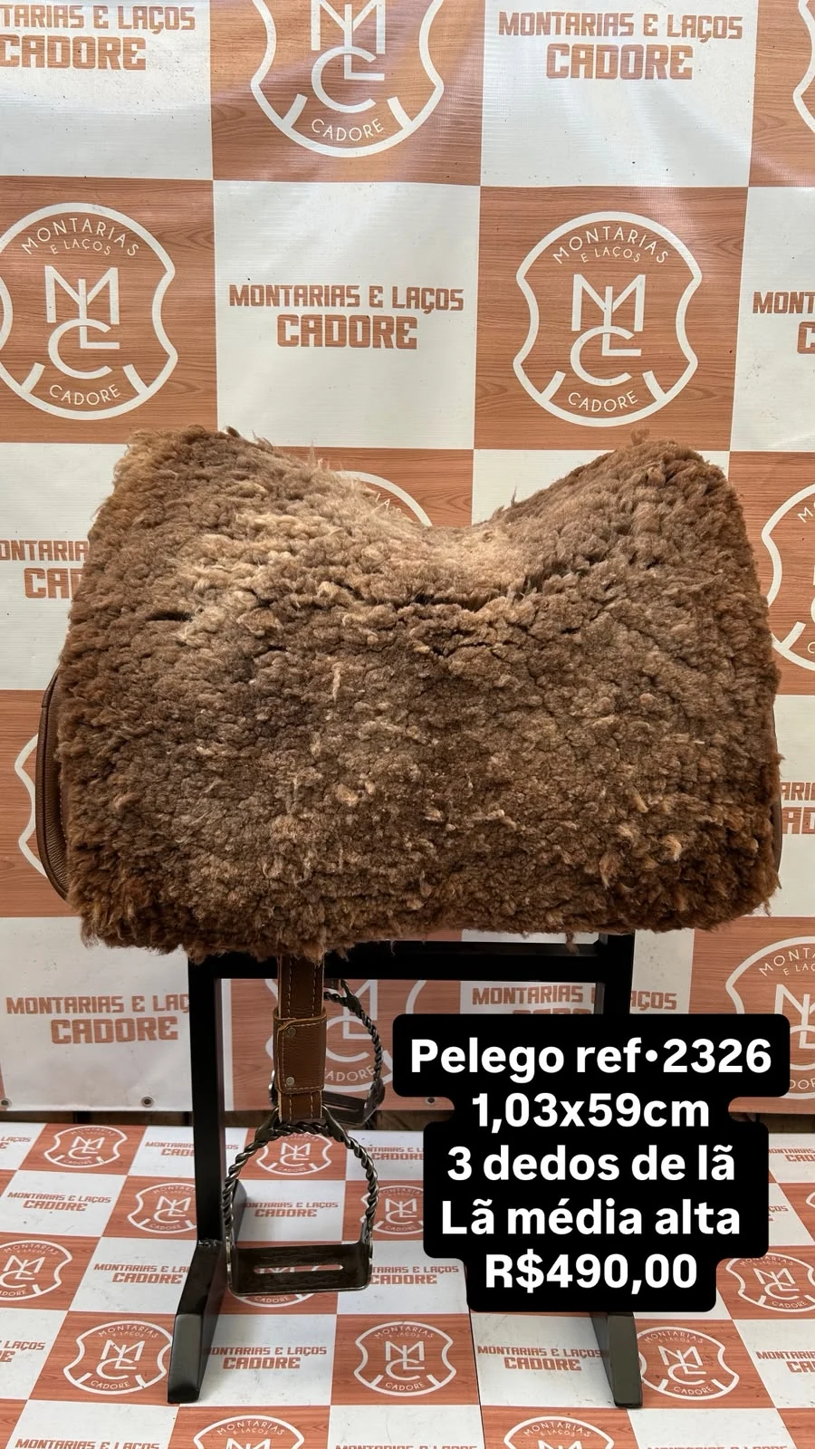 Pelego de lã sobre uma sela no cavalete, com a referência 2326, a medida e o preço escritos na foto