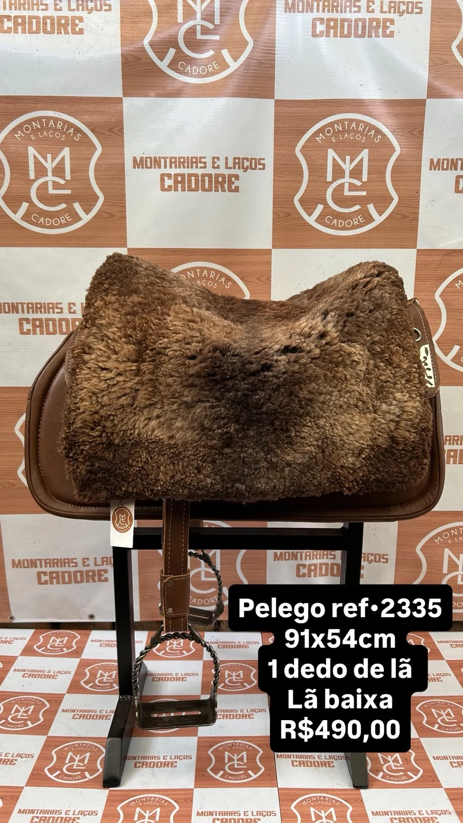 Pelego de lã sobre uma sela no cavalete, com a referência 2335, a medida e o preço escritos na foto