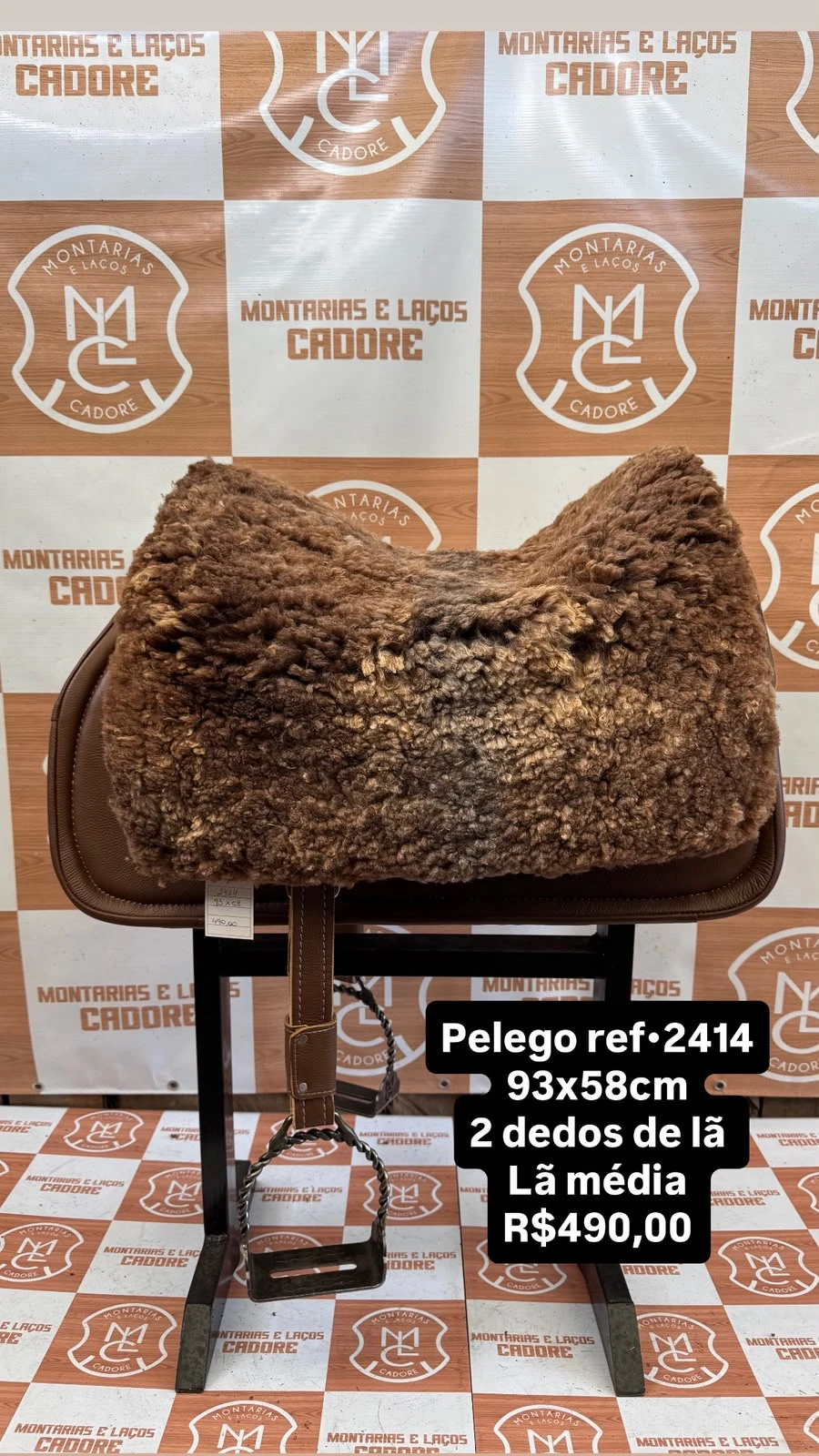 Pelego de lã sobre uma sela no cavalete, com a referência 2414, a medida e o preço escritos na foto