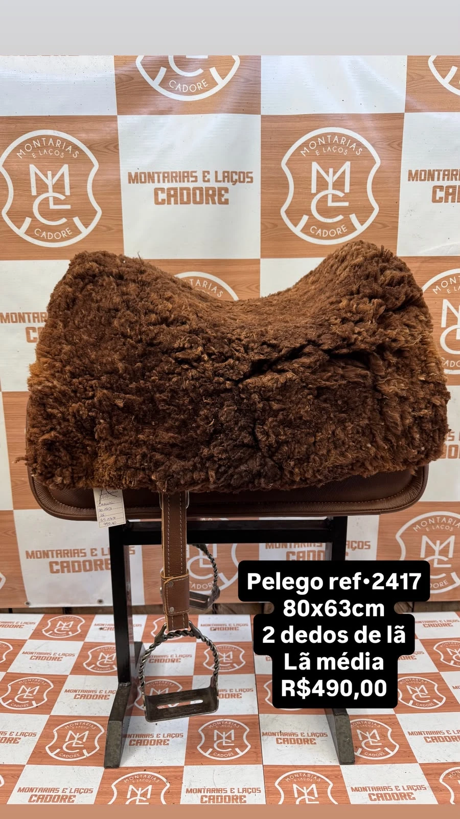 Pelego de lã sobre uma sela no cavalete, com a referência 2417, a medida e o preço escritos na foto