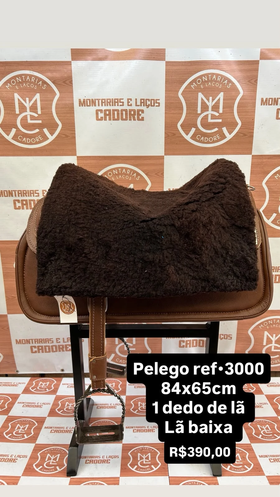 Pelego de lã sobre uma sela no cavalete, com a referência 3000, a medida e o preço escritos na foto
