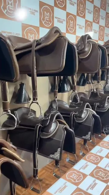 Selas penduradas na parede da loja, com o painel da marca ao fundo